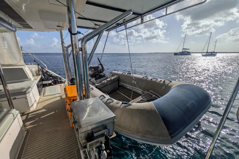 Momentum 42 Yacht Photos Pics Leopard 42 catamaran deck with dinghy, ocean view, and distant sailboats, 2023 model.