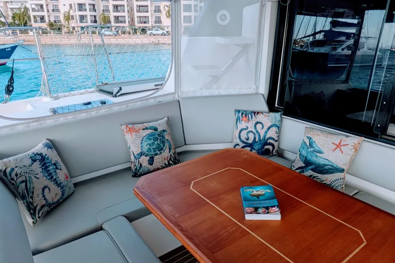 Momentum 42 Yacht Photos Pics Luxurious 2023 Leopard 42 yacht interior with nautical-themed cushions and a wooden table.