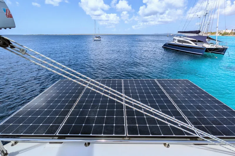 Momentum 42 Yacht Photos Pics Leopard 42 catamaran with solar panels on deck, anchored in clear blue waters, 2023 model.