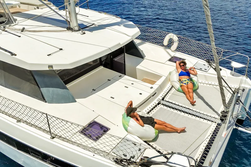Momentum 42 Yacht Photos Pics Two people relaxing on a 2023 Leopard 42 catamaran, enjoying the sun and sea.