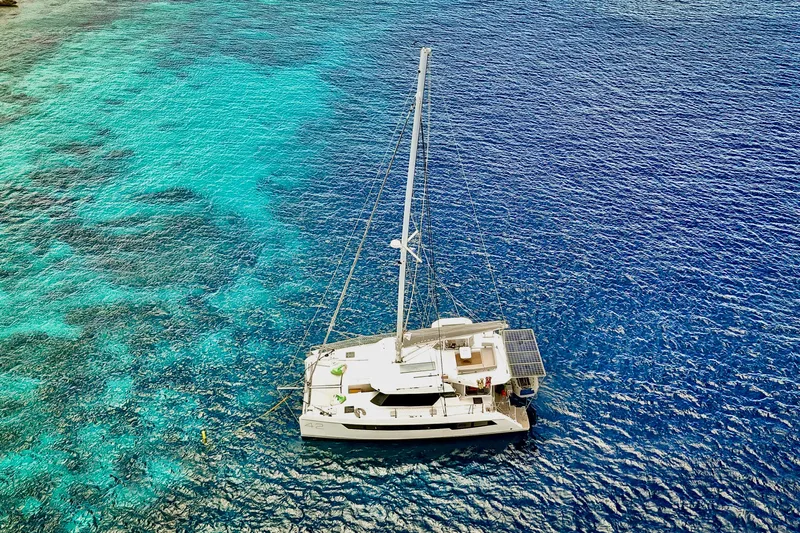Momentum 42 Yacht Photos Pics Aerial view of 2023 Leopard 42 catamaran sailing on vibrant blue ocean waters.