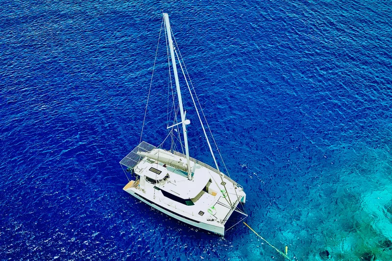 Momentum 42 Yacht Photos Pics Aerial view of 2023 Leopard 42 catamaran sailing in vibrant blue ocean waters.