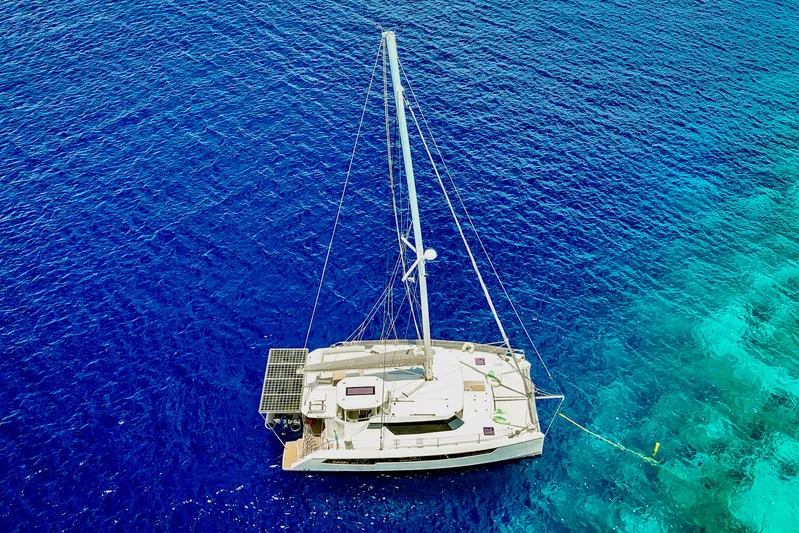 Momentum 42 Yacht Photos Pics Aerial view of 2023 Leopard 42 catamaran sailing on vibrant blue ocean waters.