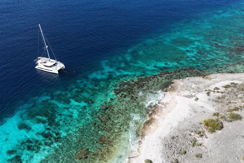 Momentum 42 Yacht Photos Pics Aerial view of Leopard 42 yacht near a rocky coastline with turquoise waters, 2023 model.