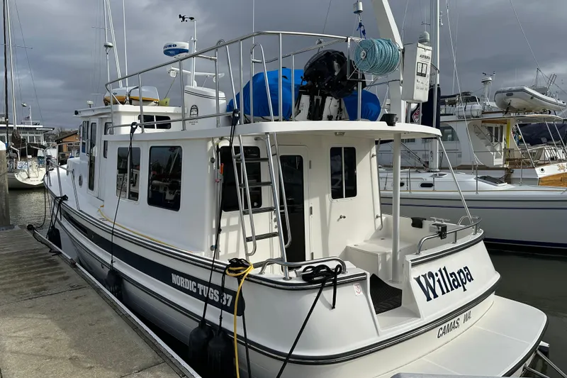 Willapa Yacht Photos Pics 2005 Nordic Tug 37 docked at marina, featuring white exterior and nautical equipment.