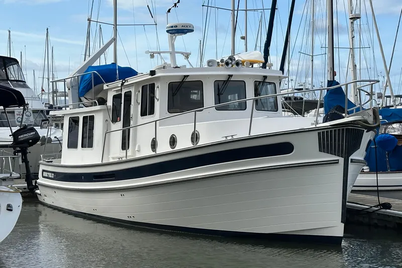 Willapa Yacht Photos Pics 2005 Nordic Tug 37 docked at a marina, surrounded by sailboats.