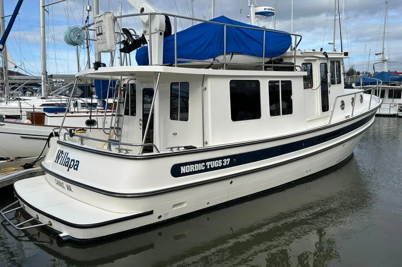 Willapa Yacht Photos Pics 2005 Nordic Tug 37 docked in marina, featuring white hull and blue accents.