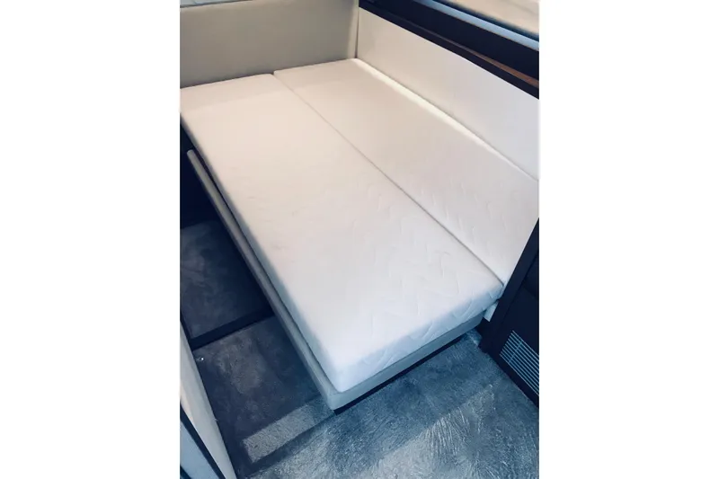 Improbable Yacht Photos Pics Interior view of a 2019 Prestige 520 yacht featuring a compact, white cushioned seating area.