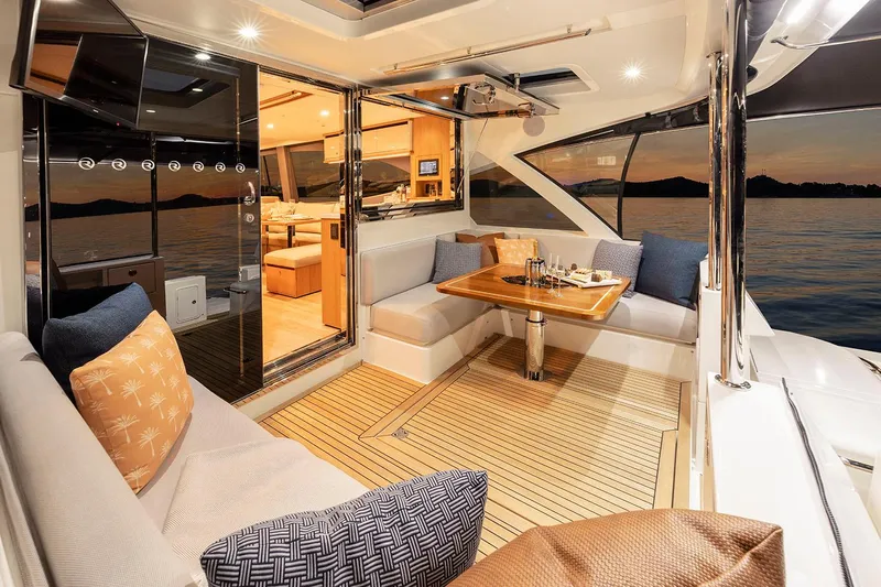  Yacht Photos Pics Manufacturer Provided Image: Luxurious 2025 Riviera 585 SUV yacht interior with elegant seating and dining area at sunset.