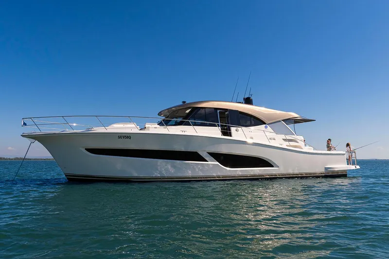 Yacht Photos Pics Manufacturer Provided Image: 2025 Riviera 585 SUV yacht cruising on open water under clear blue sky.