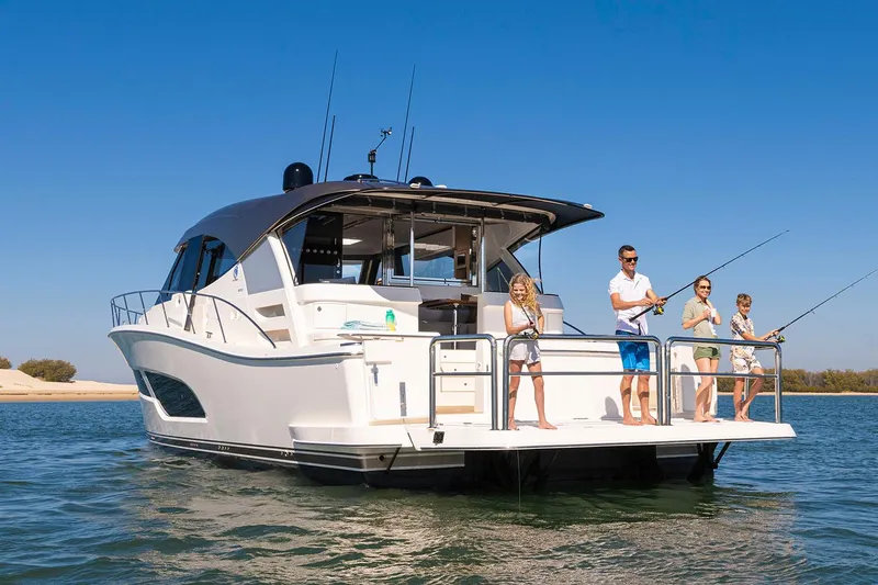  Yacht Photos Pics Manufacturer Provided Image: 2025 Riviera 585 SUV yacht with people fishing on deck in sunny waters.