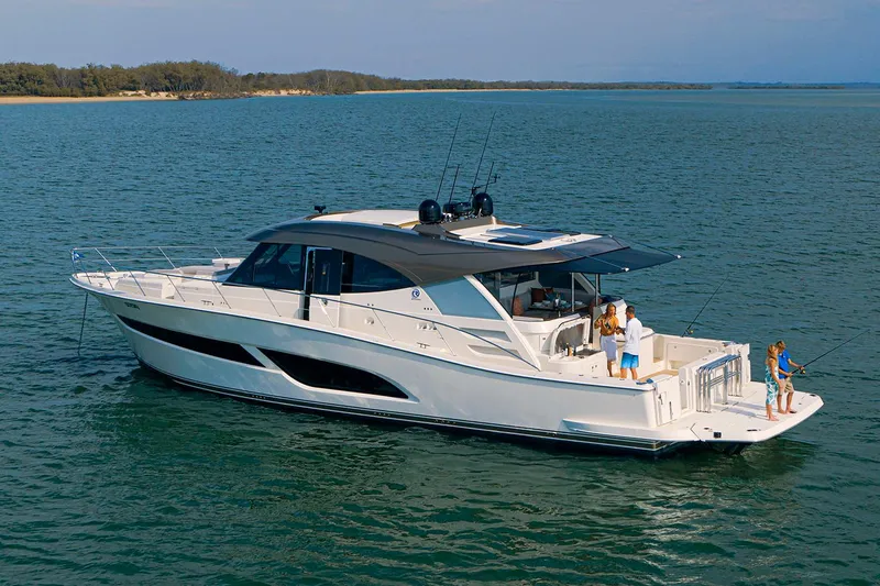  Yacht Photos Pics Manufacturer Provided Image: 2025 Riviera 585 SUV yacht cruising on serene waters with people on deck.