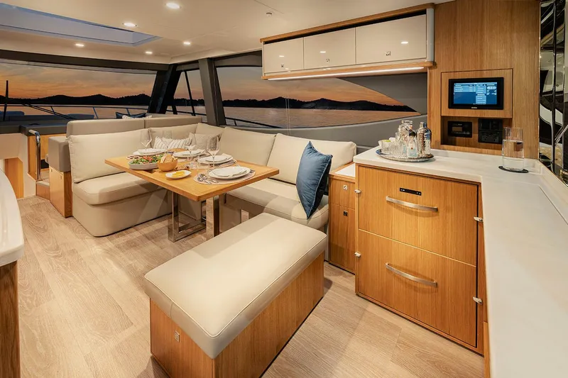  Yacht Photos Pics Manufacturer Provided Image: Luxurious interior of 2025 Riviera 585 SUV yacht with elegant dining area and sunset view.