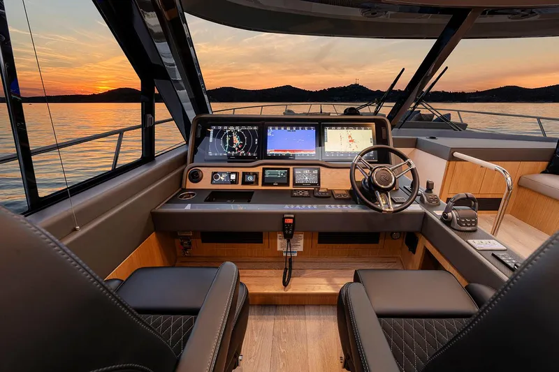  Yacht Photos Pics Manufacturer Provided Image: 2025 Riviera 585 SUV yacht interior with modern dashboard at sunset.
