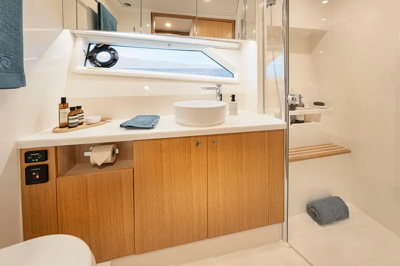  Yacht Photos Pics Manufacturer Provided Image: Luxurious bathroom in 2025 Riviera 585 SUV yacht with modern fixtures and wooden cabinetry.