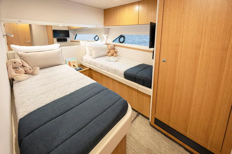  Yacht Photos Pics Manufacturer Provided Image: Luxurious 2025 Riviera 585 SUV cabin with twin beds and elegant wood finish.