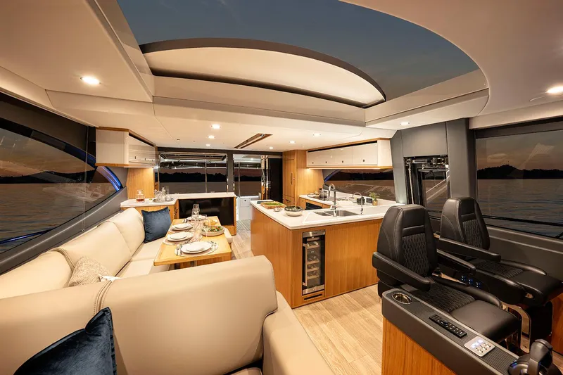  Yacht Photos Pics Manufacturer Provided Image: Luxurious interior of 2025 Riviera 585 SUV yacht with modern kitchen and seating area.
