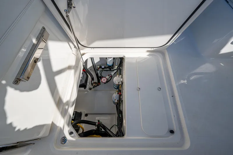  Yacht Photos Pics 2021 Pursuit DC 266 Dual Console boat storage compartment with visible mechanical components.