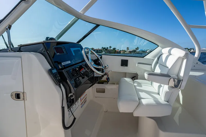  Yacht Photos Pics 2021 Pursuit DC 266 Dual Console boat interior with steering wheel and white seating.