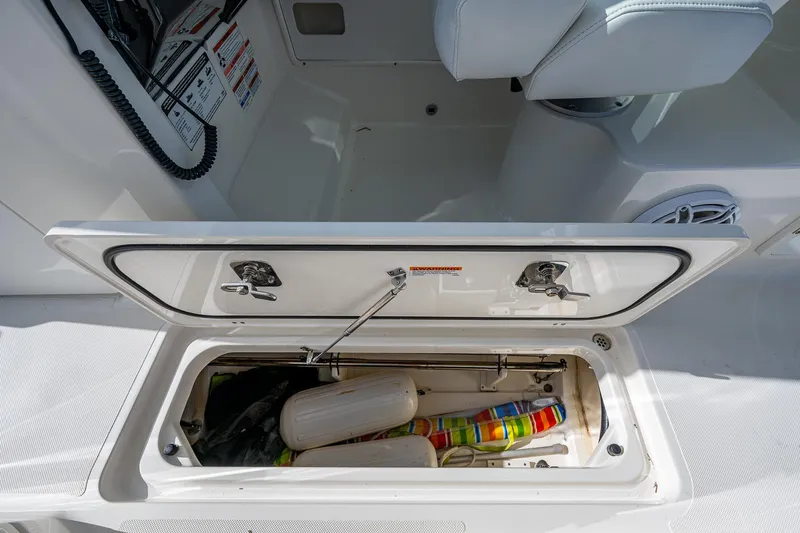  Yacht Photos Pics Storage compartment on a 2021 Pursuit DC 266 Dual Console boat, containing boating accessories.
