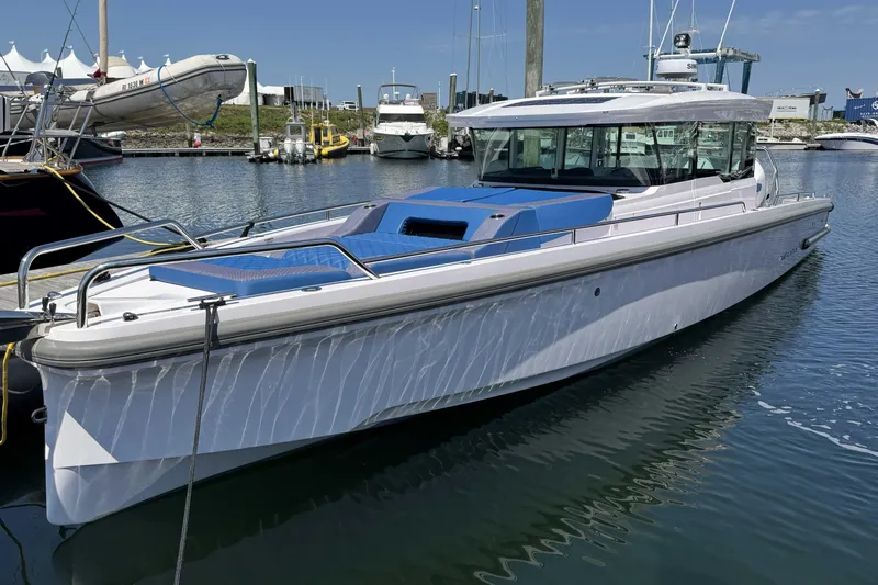  Yacht Photos Pics 2024 Axopar 37 XC CROSS CABIN boat docked in a marina under clear skies.