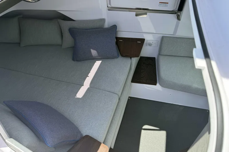  Yacht Photos Pics 2024 Axopar 37 XC CROSS CABIN interior with gray seating and blue cushions.