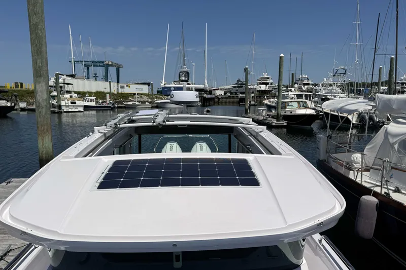  Yacht Photos Pics 2024 Axopar 37 XC CROSS CABIN docked at marina, featuring solar panel on roof.