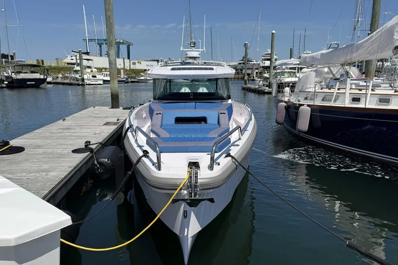  Yacht Photos Pics 2024 Axopar 37 XC CROSS CABIN docked at a marina, surrounded by other boats.
