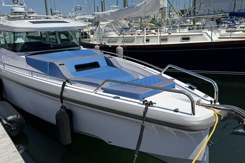  Yacht Photos Pics 2024 Axopar 37 XC CROSS CABIN boat docked with blue seating and sleek design.
