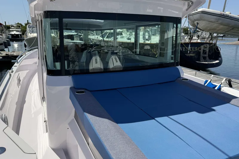  Yacht Photos Pics 2024 Axopar 37 XC CROSS CABIN boat with blue sunbed, docked at marina.