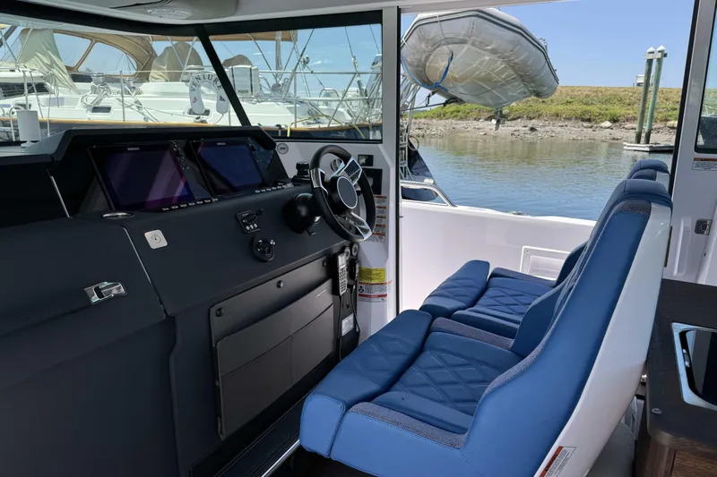  Yacht Photos Pics 2024 Axopar 37 XC CROSS CABIN interior with blue seating and modern dashboard.