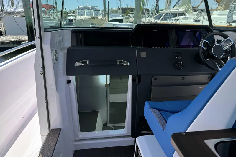  Yacht Photos Pics 2024 Axopar 37 XC CROSS CABIN interior with helm and blue seating.