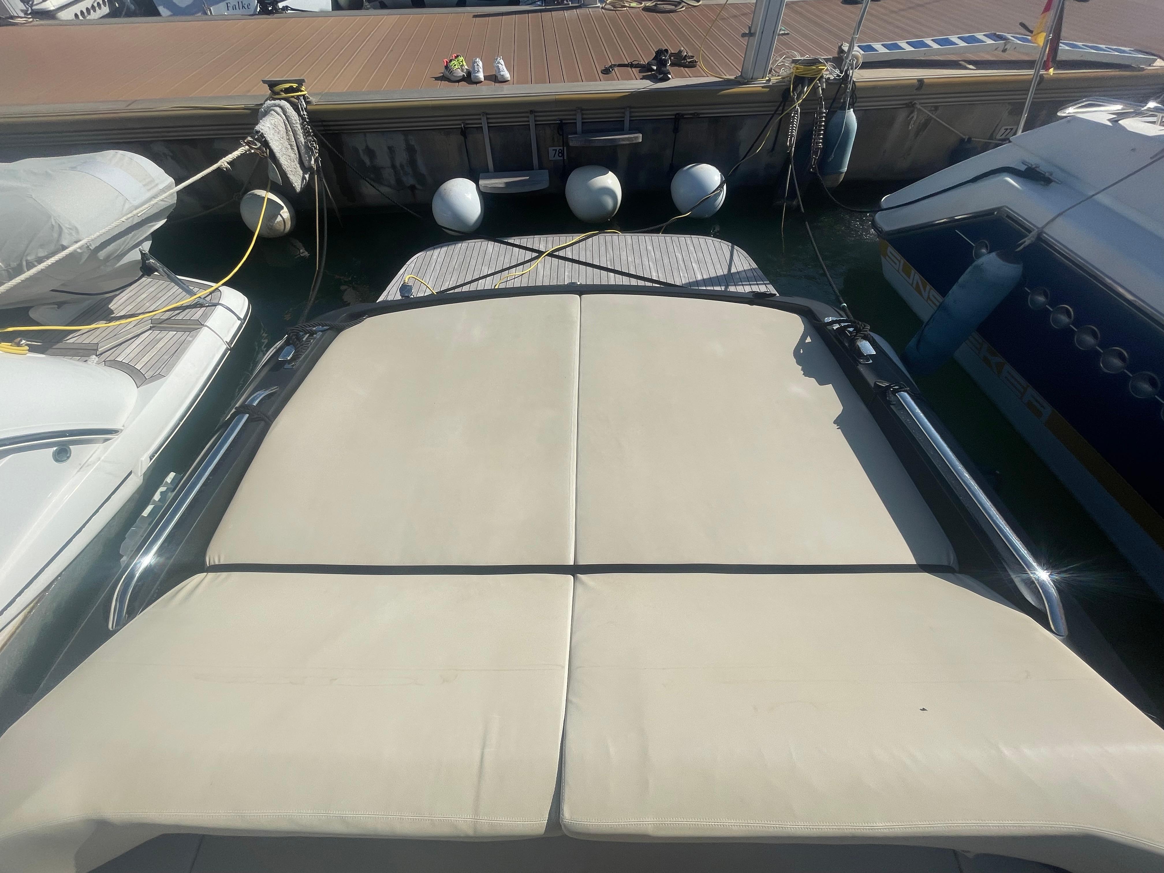 Docked boats with beige sunbeds, viewed from above, featuring a Scanner Envy 950 model.