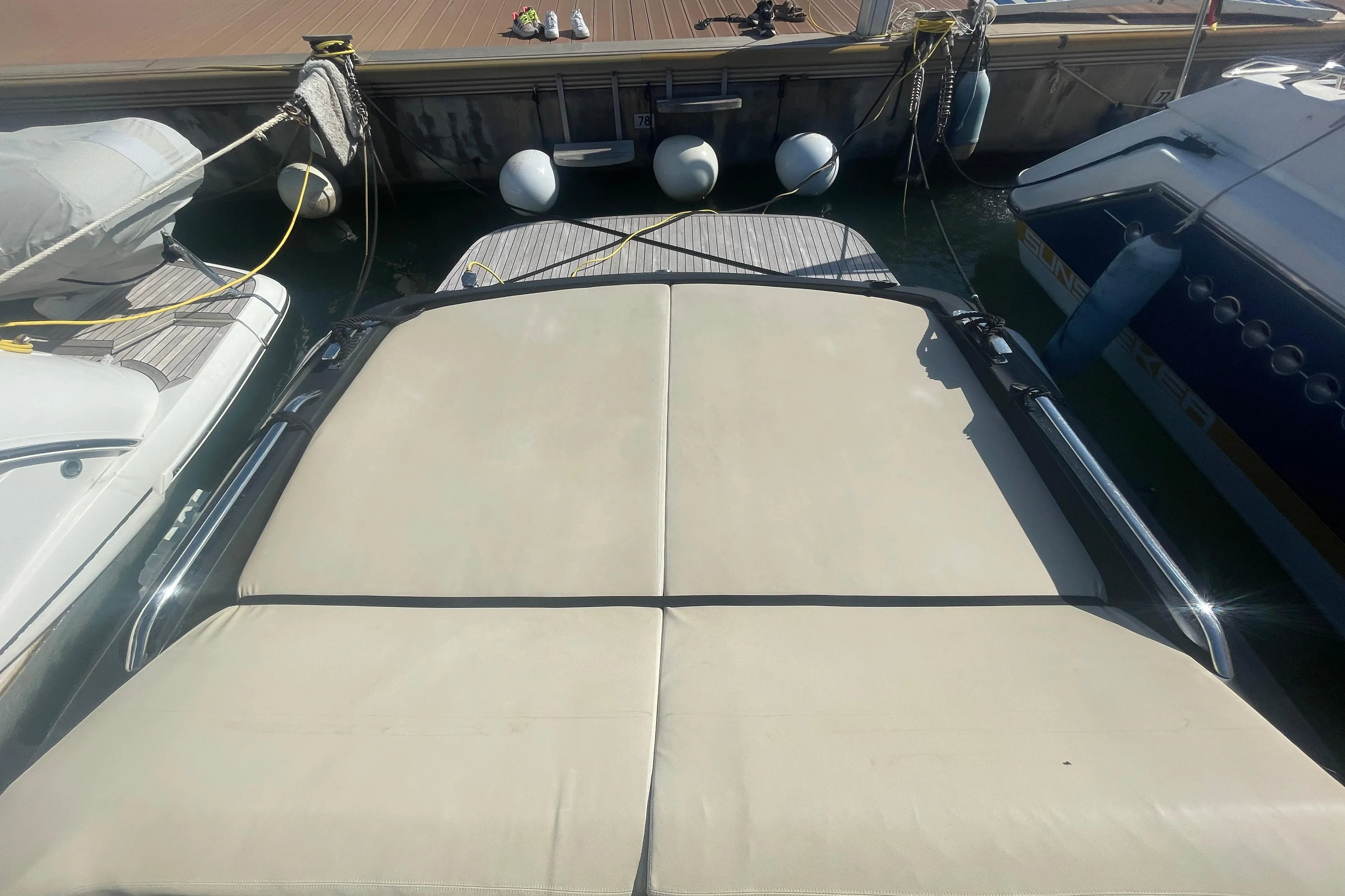 Docked boats with beige sunbeds, viewed from above, featuring a Scanner Envy 950 model.