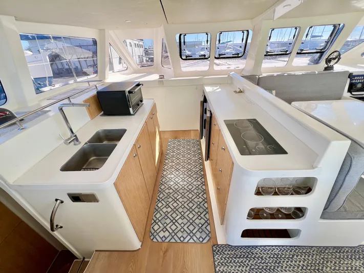 Windsurfer Yacht Photos Pics Modern kitchen interior of 2022 Custom Max Cruise 44SC yacht, featuring sleek design and ample windows.