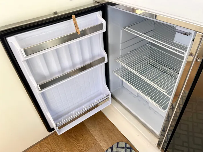 Windsurfer Yacht Photos Pics Open refrigerator in 2022 Max Cruise 44SC yacht, featuring empty shelves and door storage.