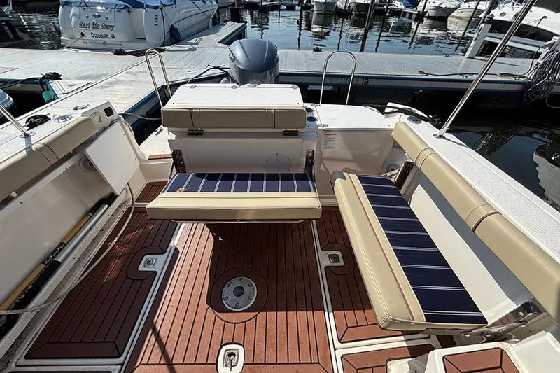  Yacht Photos Pics 2021 Ranger Tugs R-27 boat interior with cushioned seating and wooden deck at marina.