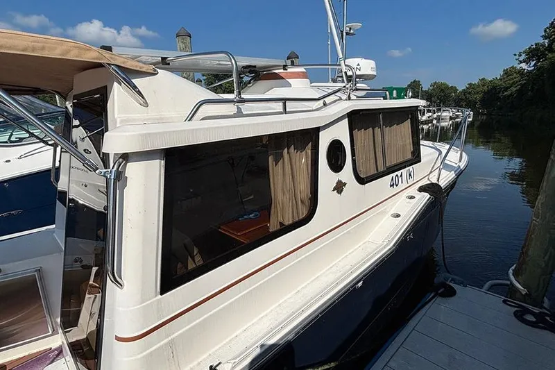  Yacht Photos Pics 2021 Ranger Tugs R-27 docked, featuring sleek design and spacious cabin windows.