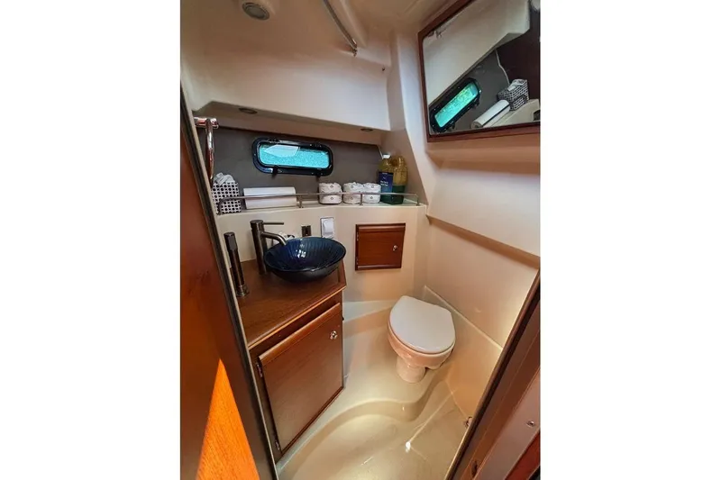  Yacht Photos Pics 2021 Ranger Tugs R-27 boat bathroom with sink, toilet, and storage cabinets.