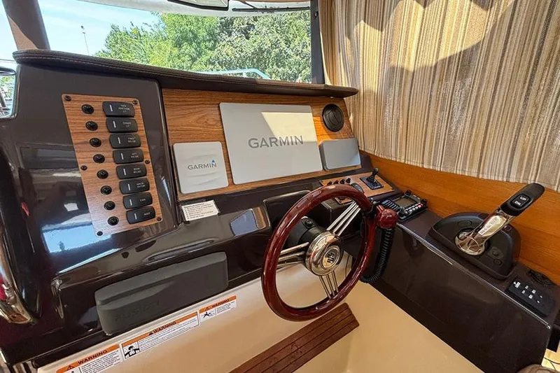  Yacht Photos Pics 2021 Ranger Tugs R-27 helm with Garmin navigation, wood accents, and steering wheel.