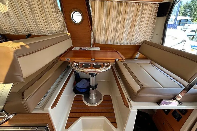  Yacht Photos Pics Interior of 2021 Ranger Tugs R-27 with seating and wooden table.
