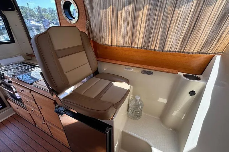  Yacht Photos Pics 2021 Ranger Tugs R-27 interior with seating, kitchenette, and wood accents.