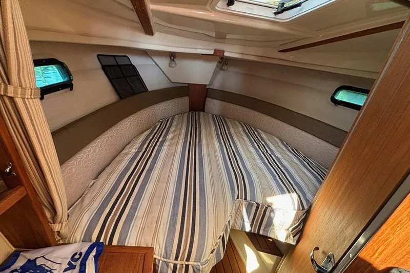  Yacht Photos Pics 2021 Ranger Tugs R-27 cabin interior with striped bedding and natural light.