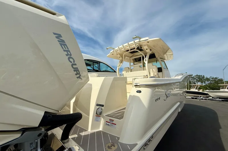  Yacht Photos Pics 2026 Scout 400 LXF Li-Ion boat with Mercury engine, docked under a clear sky.