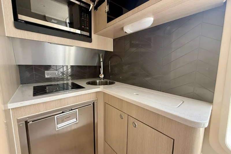  Yacht Photos Pics Modern kitchen in 2026 Scout 400 LXF Li-Ion boat with sleek appliances and stylish backsplash.