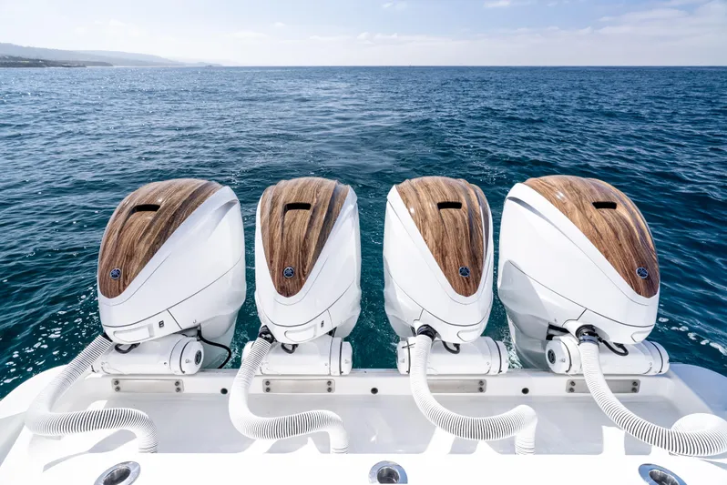  Yacht Photos Pics Four powerful outboard motors on a 2020 HCB 53 Sueños boat, ocean backdrop.
