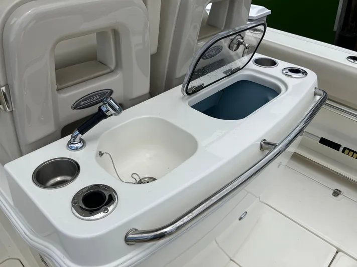  Yacht Photos Pics Boston Whaler 280 Outrage 2020 boat sink and storage area with faucet and cup holders.