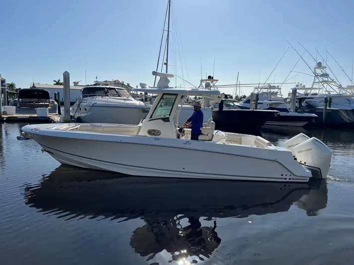  Yacht Photos Pics 2020 Boston Whaler 280 Outrage boat docked in a marina under clear skies.