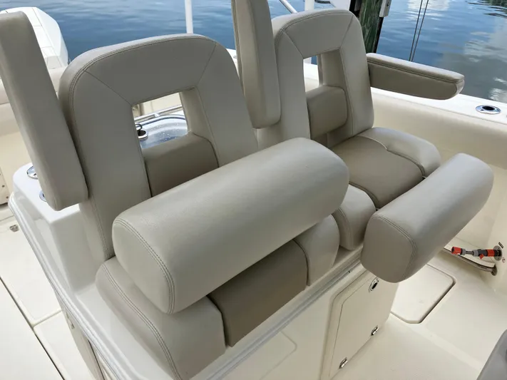  Yacht Photos Pics 2020 Boston Whaler 280 Outrage boat seats with beige upholstery, docked by water.