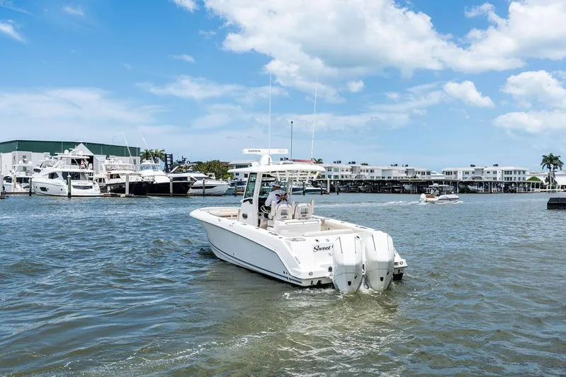  Yacht Photos Pics 2020 Boston Whaler 280 Outrage boat cruising in a marina under a blue sky.